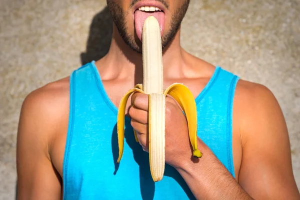 ゲイのプライドお祝いに半皮の黄色いバナナを舐める若い同性愛者の男セクシー。レズビアン、ゲイ、バイセクシャル、トランスジェンダーLGBTコミュニティの権利支援. — ストック写真