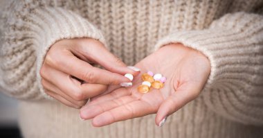 Kadın ellerine haplar, vitaminler, mineraller ve takviyelerle yaklaşın.