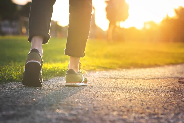 Una donna che cammina nel parco, all'aperto. Primo piano su scarpe con jeans arrotolati. Sto facendo un passo. Nuovo concetto di vita — Foto Stock