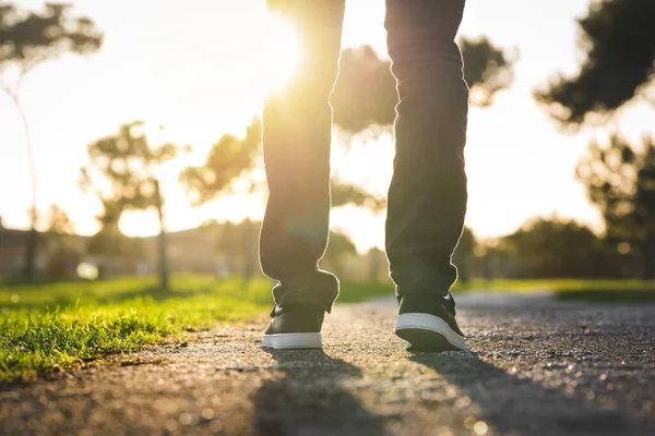 Perto do homem ambulante ao pôr-do-sol no parque. Andando ao ar livre. Fechar o sapato, dar um passo — Fotografia de Stock