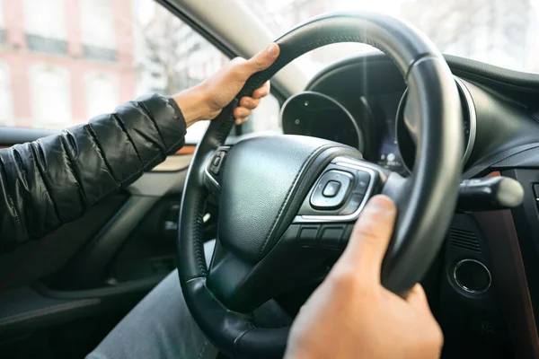 Een man die auto rijdt. Close-up van de handen van de bestuurder op het stuurwiel — Stockfoto