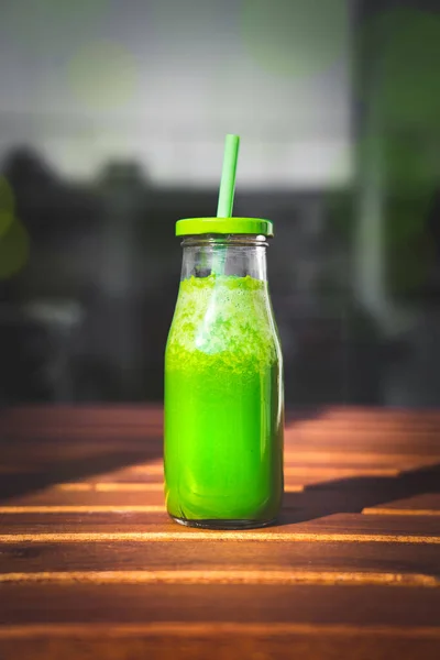 Garrafa de smoothie verde de desintoxicação saudável fresco com espinafre, maçã verde, kiwi e couve na mesa de madeira — Fotografia de Stock