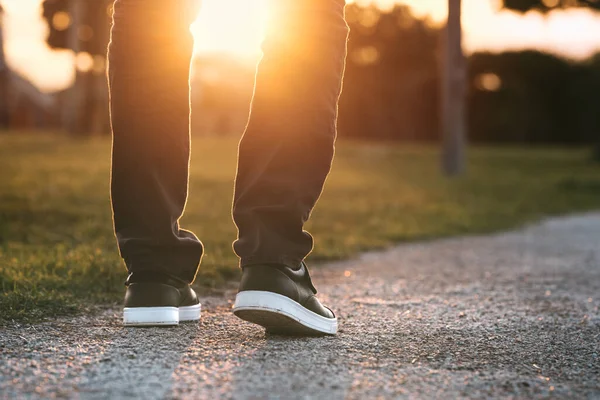 男は日没時に公園の外を歩く。新しいより良い生活に向かう途中の男。前へ進め。新しいスタート、新しい人生と自由の概念. — ストック写真