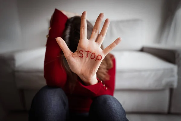 家庭内暴力の女性被害者。家庭内虐待を恐れている女性。女性の手で書かれた停止記号 — ストック写真
