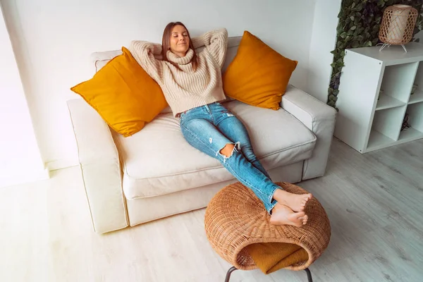 Calmo satisfeito mulher relaxar ou dormir no sofá na sala de estar. Senhora despreocupada descansando em casa, desfrutando de estresse fim de semana livre. Dia de folga. Estilo de vida em casa, conceito de conforto doméstico. — Fotografia de Stock