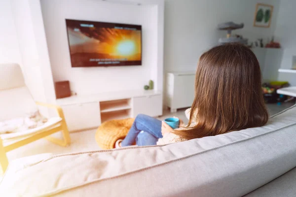 Młoda kobieta relaksuje się i odpoczywa w domu. Oglądam film albo telewizję. Cieszy leniwy weekend lub wakacje. Pomysł na dzień wolny. Styl życia. — Zdjęcie stockowe