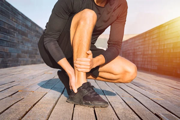 Fitter Läufer mit Knöchelschmerzen oder Achillessehnenverletzung. Unfall mit Verstauchung des Knöchels. Laufsportverletzung — Stockfoto