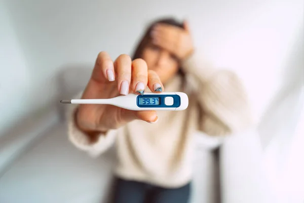 Mulher doente com febre alta. Mulher insalubre segurando um termômetro médico na mão com temperatura corporal muito alta 39,3 — Fotografia de Stock