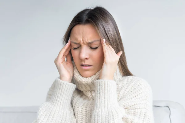 Junge Frau berührt ihre Schläfen wegen starker Spannungskopfschmerzen. Clusterkopfschmerz. Frauen leiden unter Migräne oder Stress. Hände auf den Kopf. Hochwertiges Foto — Stockfoto