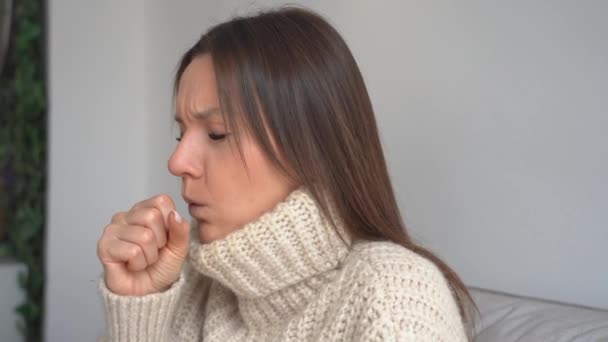 Jonge zieke vrouw met hoesten en keelpijn. Dan hoest er thuis een vrouw. Griep, keelpijn, luchtweginfectie, longontsteking of bronchitis symptomen — Stockvideo