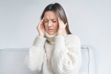 Kadın şakaklarına dokunuyor çünkü baş ağrısı var. Küme baş ağrısı, migren veya stres