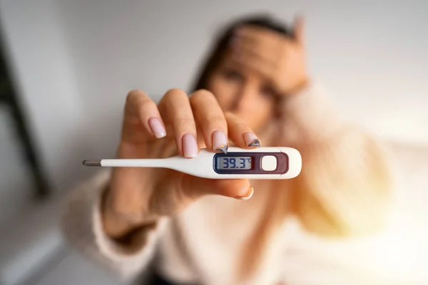 Mulher doente com febre alta apresentando termômetro com temperatura corporal elevada 39,3 — Fotografia de Stock