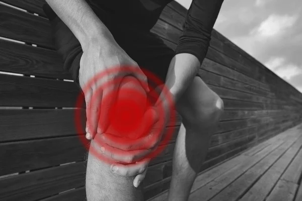 Ο άντρας κρατάει το πονεμένο του γόνατο. Άσκηση τραυματισμού στο γόνατο και πόνο. Τραυματισμός από προπόνηση — Φωτογραφία Αρχείου