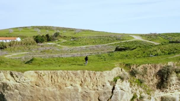 在阳光灿烂的一天，年轻的运动员在悬崖边奔跑的空中无人驾驶镜头。运动员在户外慢跑 — 图库视频影像