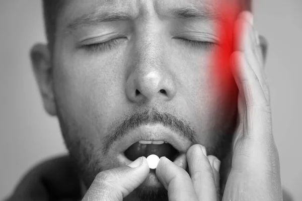 Homem sofrendo de dor de cabeça e tomando analgésicos para aliviar a dor. Comprimido ou comprimido de enxaqueca, tensão ou dor de cabeça em cluster — Fotografia de Stock