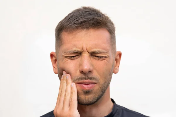 Мужчина чувствует сильную зубную боль. Человек, страдающий зубной болью, стоматологическими заболеваниями или заболеваниями полости рта. Проблема с зубами — стоковое фото