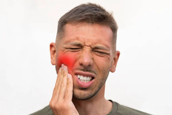 Homem tocando sua bochecha por causa de forte dor dentária com área vermelha destacada. Homem que sofre de dor de dente. Problema dos dentes. Homem sentindo dor de dente — Fotografia de Stock