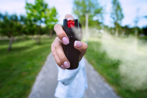Mulher usando spray de pimenta ou gás lacrimogêneo para autodefesa ao ar livre — Fotografia de Stock