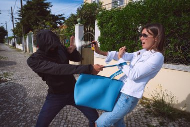 Hırsız ya da maskeli bir soyguncu dışarıda kadın çantası çalmaya çalışıyor. Kadın kendini korumak için biber gazı ya da göz yaşartıcı gaz kullanıyor. Kadın hırsıza karşı kendini savunuyor..