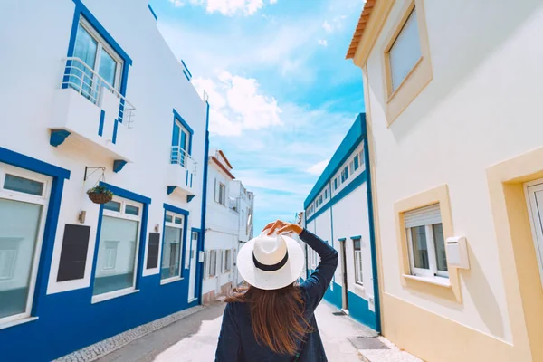 Vista posteriore di una giovane turista con cappello bianco che passeggia per le stradine del sud del Portogallo in una giornata estiva soleggiata. Vacanze estive — Foto Stock