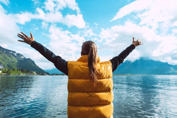 Молодая беззаботная женщина-путешественница с распростертыми объятиями наслаждается прекрасным видом на Женевское озеро в Швейцарии. — стоковое фото