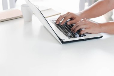 Dizüstü bilgisayarı olan genç bir adam. Evinde uzaktan çalışan, ağ hakkında fikirleri olan ya da küresel bir iş ağını uzaktan yöneten bir adam..