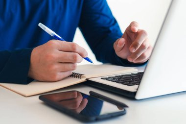 Not alan iş adamı toplantıyı online olarak özetle, yalnız çalış, masanda otur. Evden çalışıyor, yakın çekimde..
