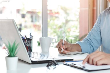 İş adamı, elinde not defterleriyle masalarında çalışır çevrimiçi müşterilerden, çevrimiçi iş ve e-ticaretten sipariş alır, çevrimiçi ürünler satar..