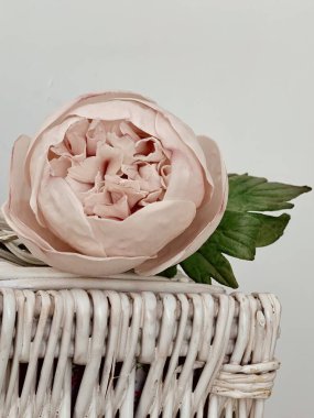 Beyaz hasır kutuda çiçek pembesi şakayığı var. 