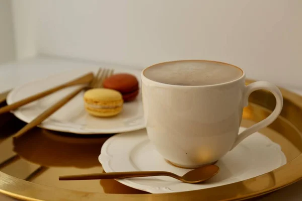 マカロンの朝食を背景にミルク入りのコーヒーを飲み — ストック写真