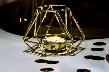 Güzel altın bir şamdanın içindeki mum bayram masasında duruyor.