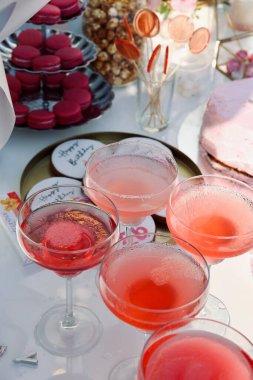 Doğum günü partisinde çiçekli, şampanyalı ve şekerli bir masa.