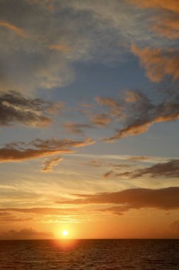 Okyanusun üzerinde güzel sarı gün batımı ve farklı renkte gökyüzü