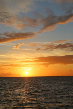 Okyanusun üzerinde güzel sarı gün batımı ve farklı renkte gökyüzü