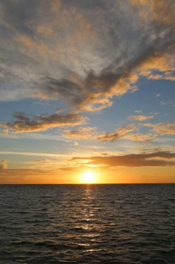 Okyanusun üzerinde güzel sarı gün batımı ve farklı renkte gökyüzü