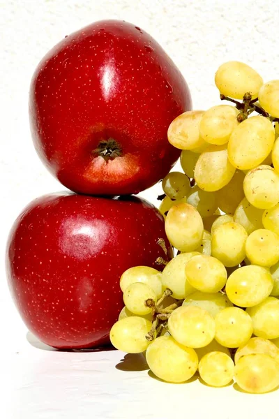 green grapes and red apples in the white background