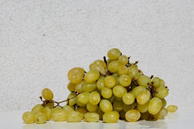  Beyaz masada bir demet yeşil üzüm.