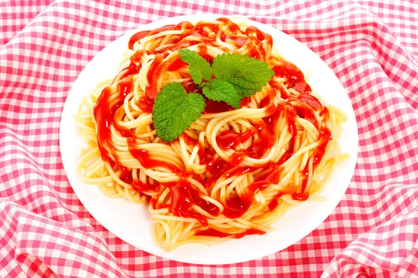 İtalyan makarna, domates sosu ve nane ekose bir masa örtüsü — Stok fotoğraf