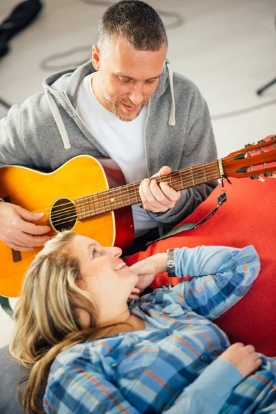 Muzikant onderwijs zijn vriendin elektrische gitaar spelen — Stockfoto