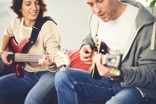 Músico enseñando a su novia a tocar la guitarra eléctrica — Foto de Stock