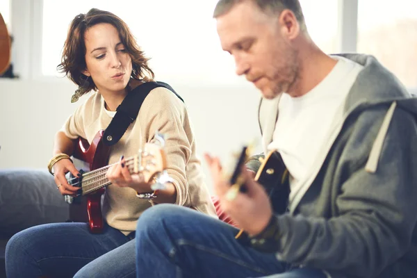 Músico enseñando a su novia a tocar la guitarra eléctrica — Foto de Stock
