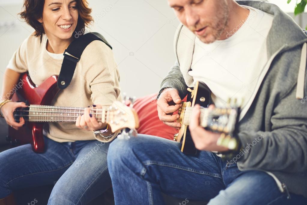 Musician teaching his girlfriend playing electric guitar