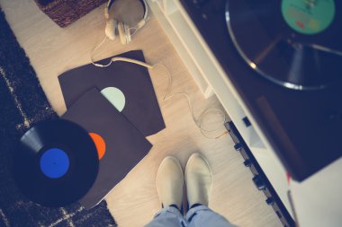 Vinil kayıtları ve gramofon arasında kadın bacakları
