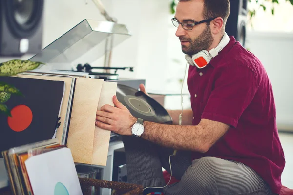 Hombre eligiendo el próximo disco de vinilo para reproducir — Foto de Stock