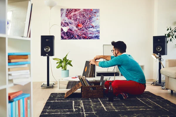 Hombre eligiendo el próximo disco de vinilo para reproducir — Foto de Stock