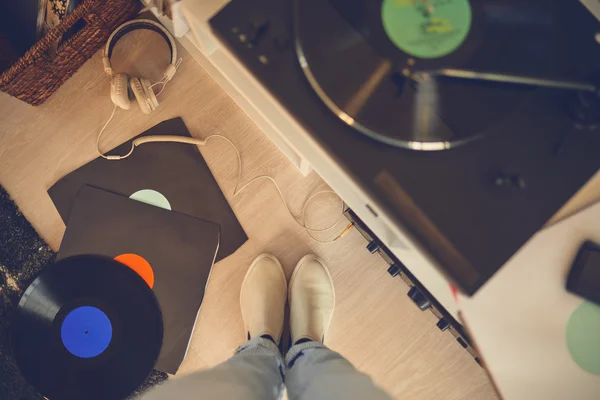 Female legs among vinyl records and gramophone — Stock Photo, Image