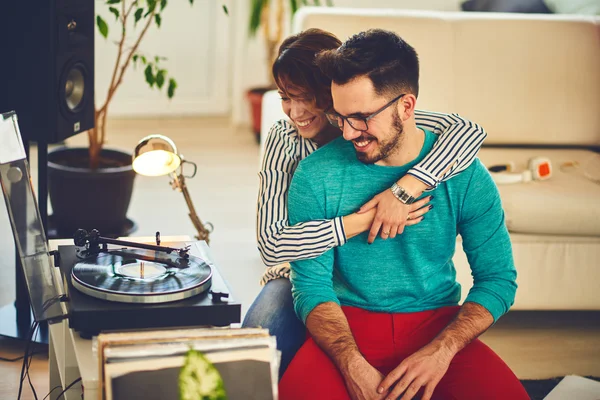 Счастливая молодая пара слушает музыку в помещении — стоковое фото