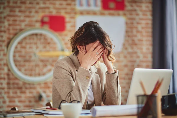 La mujer tiene dolor de cabeza en el trabajo —  Fotos de Stock