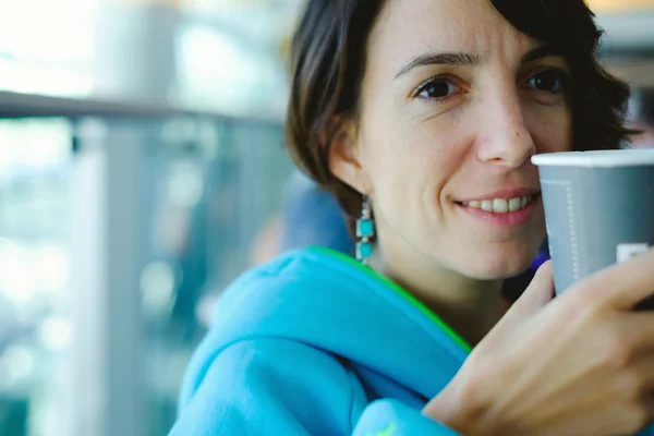 Woman drinking coffee in airport — Stock Photo, Image