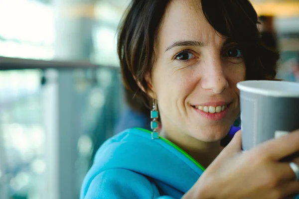 Woman drinking coffee in airport — Stock Photo, Image